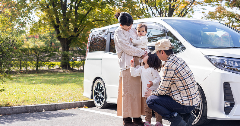 家族が車の前にいる写真