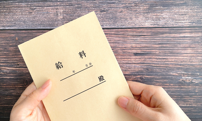 給料と書いた封筒を持っている写真